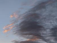 Dunkle Abendwolken über den Bergen beginnen rot zu leuchten